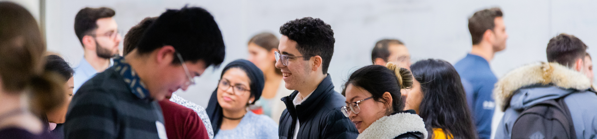 Two smiling young men stand in front of a shoe rack.