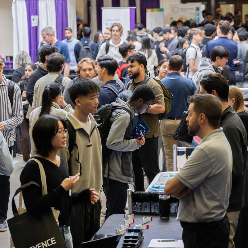 Many students stand in a crowd at a career fair.