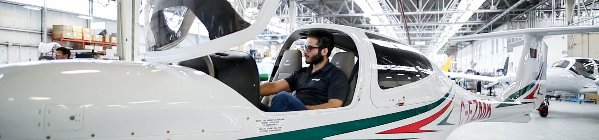 A young man sits in an aircraft.