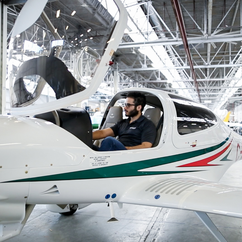 A young man sits in an aircraft.