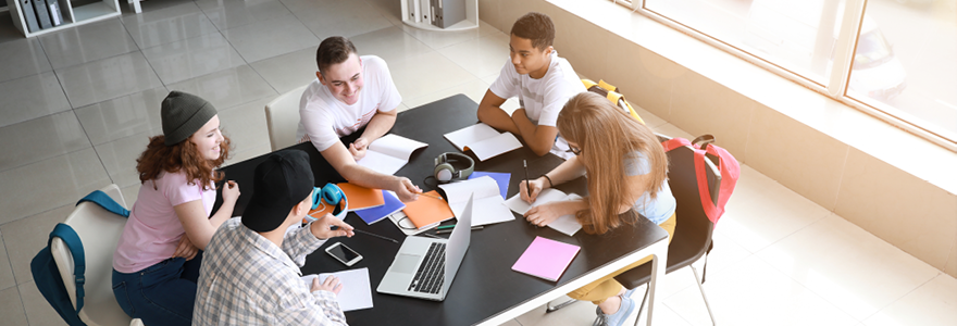 Students sitting around a table working on a project together